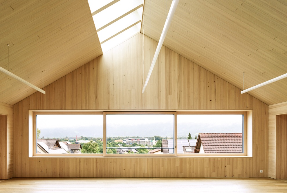 Pièce à haut plafond avec aménagement intérieur en bois et plafond incliné des deux côtés