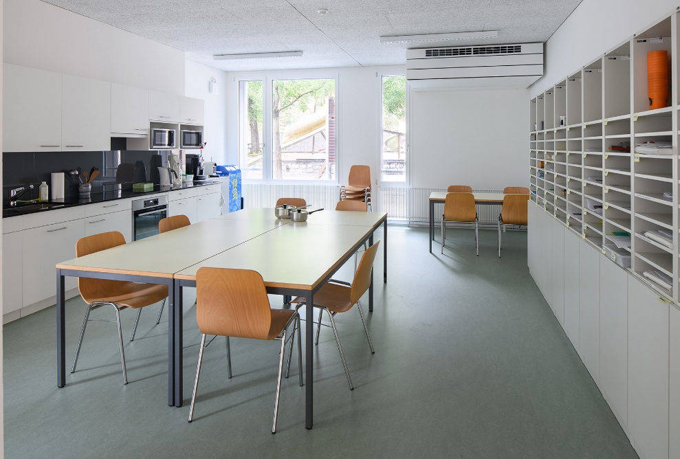 Vue intérieure de la salle des professeurs avec kitchenette et placards intégrés