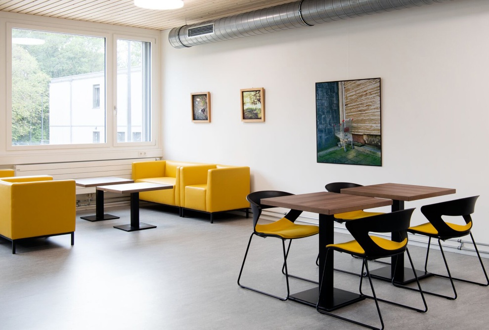 Helles Lehrerzimmer mit Besprechungstisch und Lounge