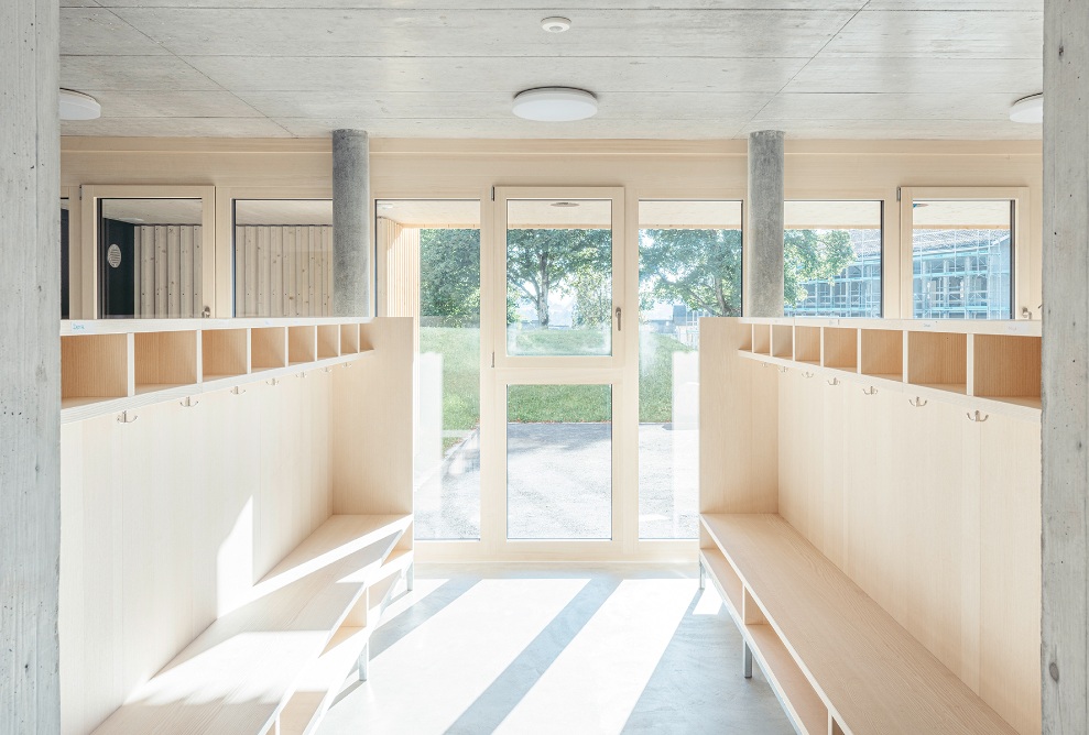 Bright entrance area with glass doors and integrated cloakroom made from wood elements