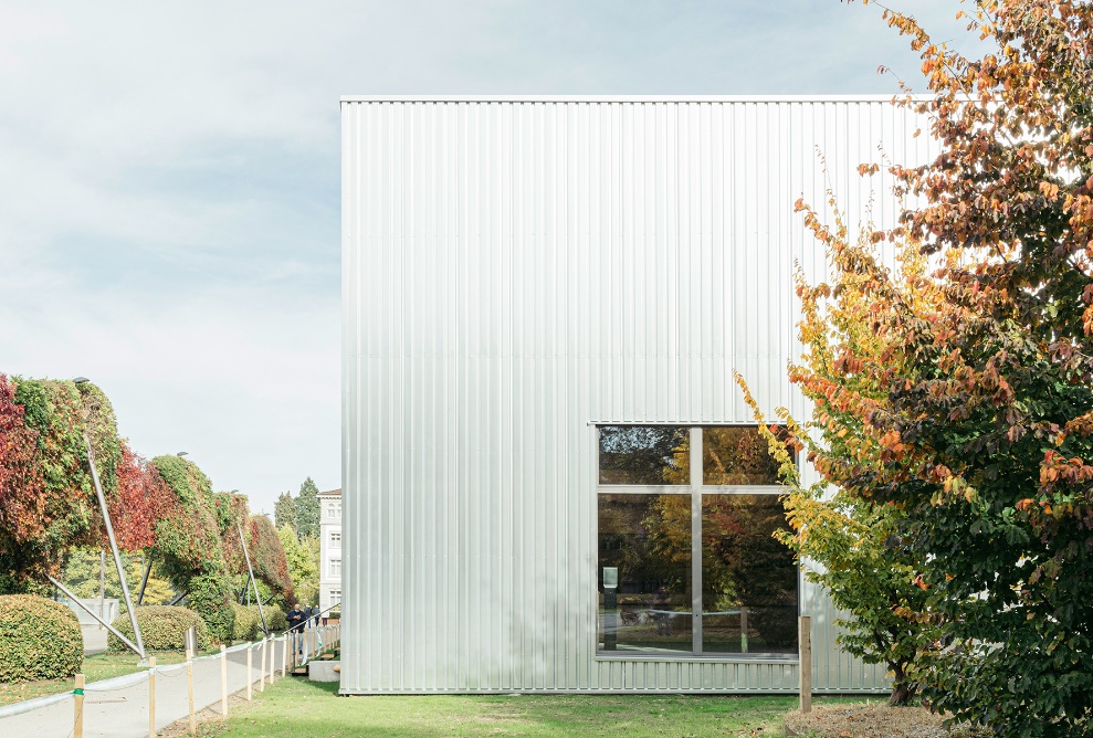 Theaterprovisorium mit hellgrauer Fassade aus Trapezblech im Brühlpark St. Gallen