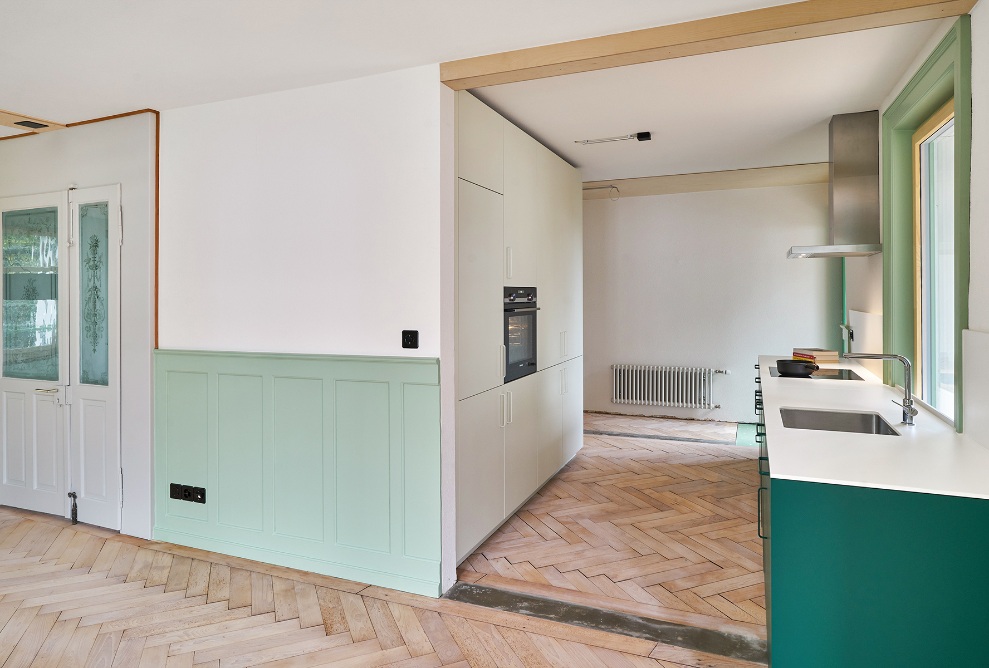 Offene Küche und Eingangsbereich mit grünen Akzenten