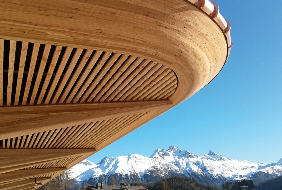 Construction en bois sur fond de ciel bleu avec des montagnes en arrière-plan.