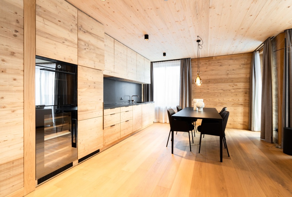 Élégante cuisine en bois avec table à manger et chaises noires