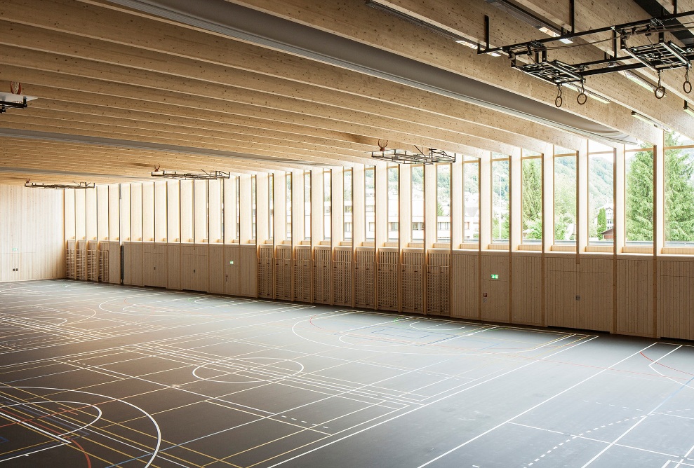 La prise de vue montre la structure du mur et du toit en bois de la salle de sport de Sargans.