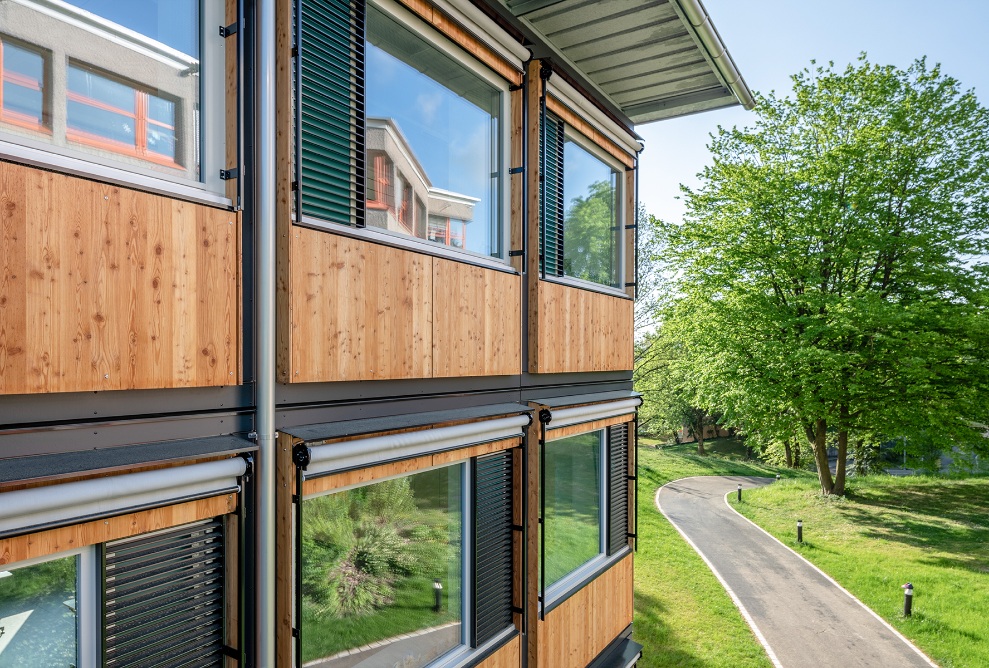 Querformatbild mit seitlicher Ansicht der Holzfassade des modularen ZM10-Schulpavillons Sihlweid in Zürich