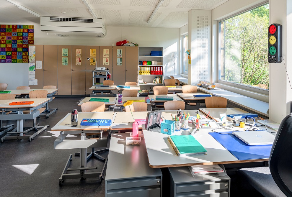 Seitliche Innenansicht eines Klassenzimmers mit heller Fensterfront im ZM10-Schulpavillon Sihlweid in Zürich