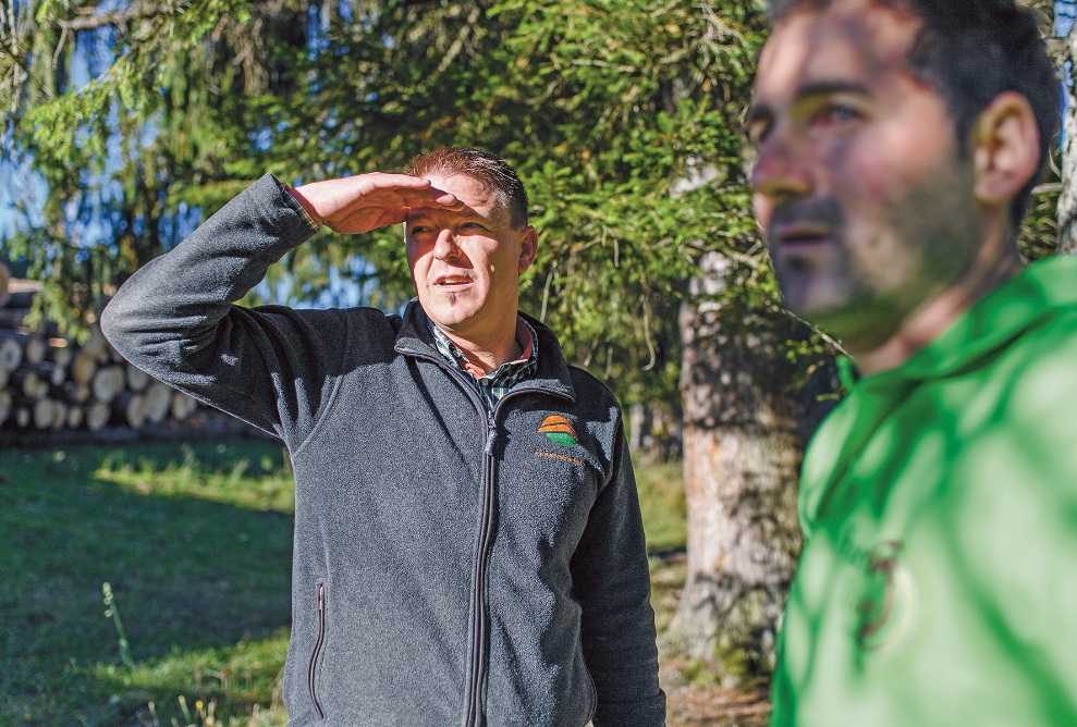 Outdoor shot of log purchaser Roger Wegmüller working with a forester