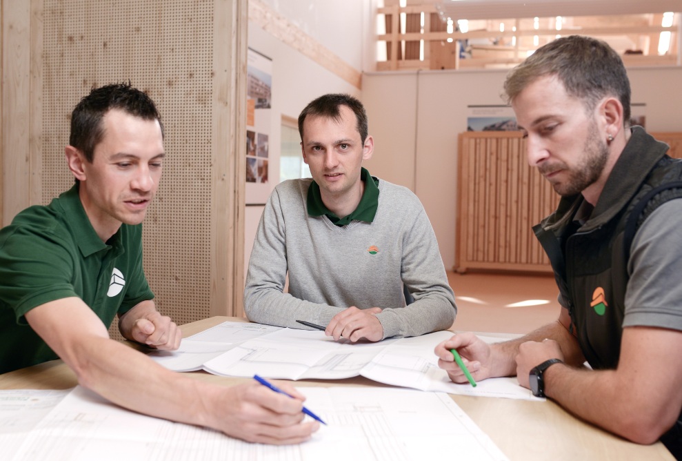 Three project managers sitting in an office, mid-discussion