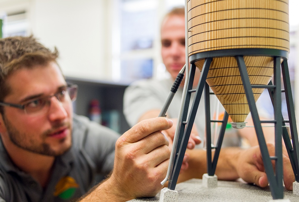 Discussion détaillée de deux collaborateurs à l’aide d’une maquette de silo