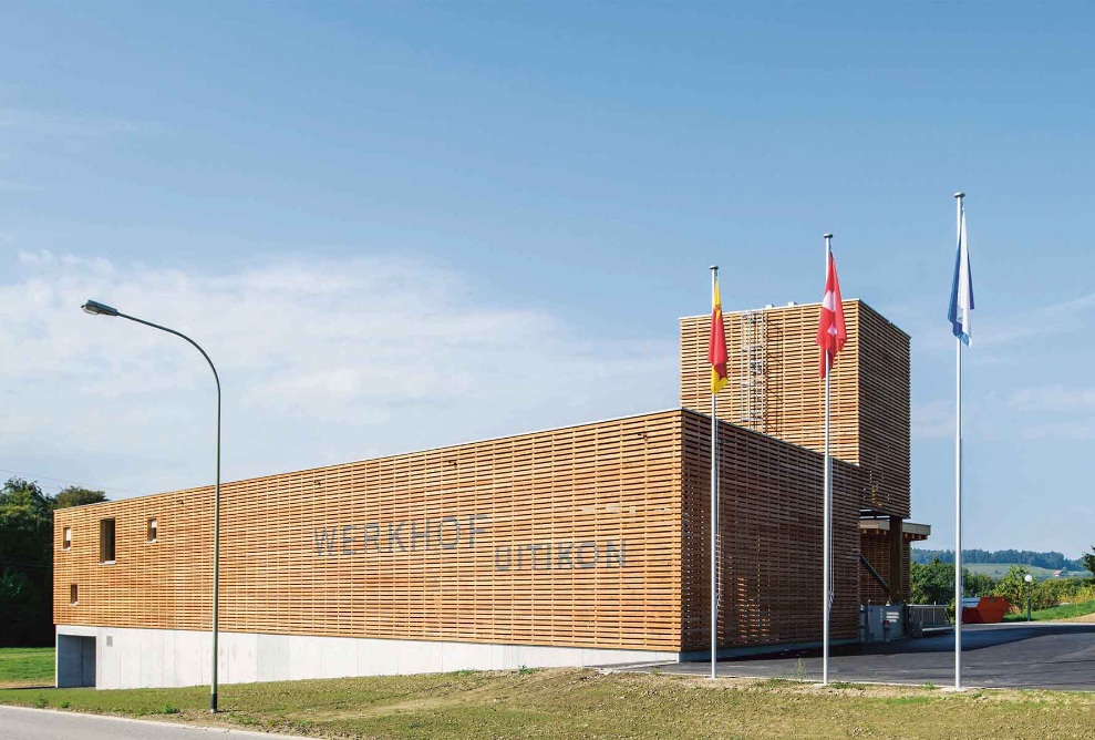 Werkhof Uitikon: un bâtiment en bois en forme d'étoile avec silo modulaire intégré pour le sel de voirie et convoyeur de renvoi mobile, hall froid et chaud, hall de lavage, hall ouvert et bâtiment industriel à deux étages